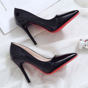 Becmella black high heel red bottom pumps for women with a glossy finish on a white fabric background